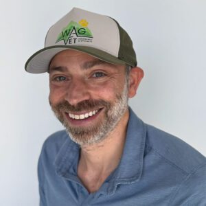 Dr. Rosenbaum wearing a WAG Vet cap and smiling